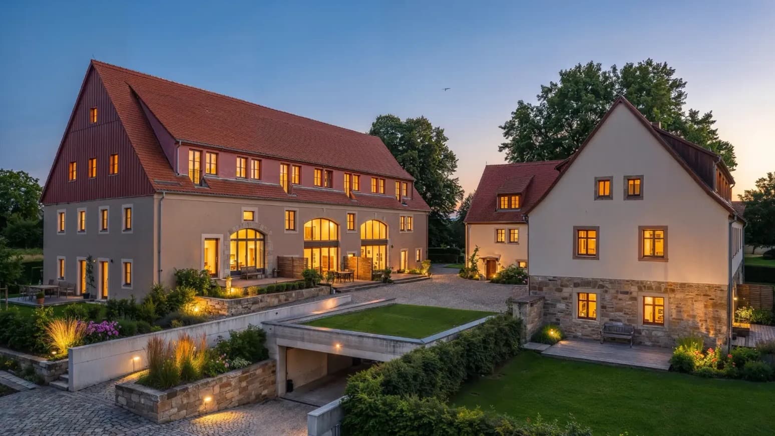BaumGut Bannewitz — Dreiseitenhof mit Scheune und Wohnhaus in der Abenddämmerung, beleuchtete Fenster