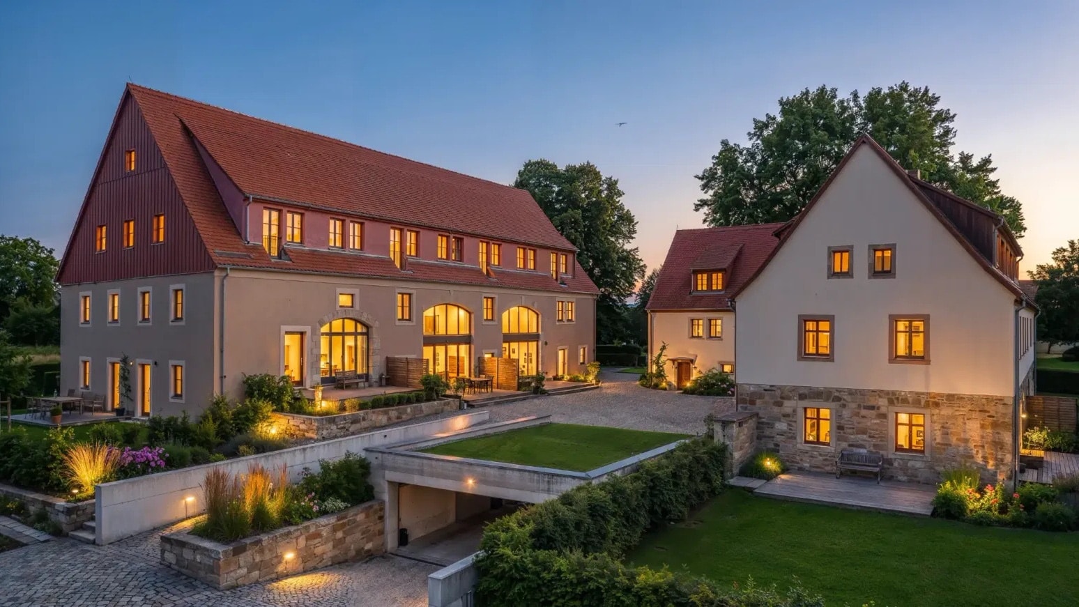 BaumGut Bannewitz — Dreiseitenhof mit Scheune und Wohnhaus in der Abenddämmerung, beleuchtete Fenster