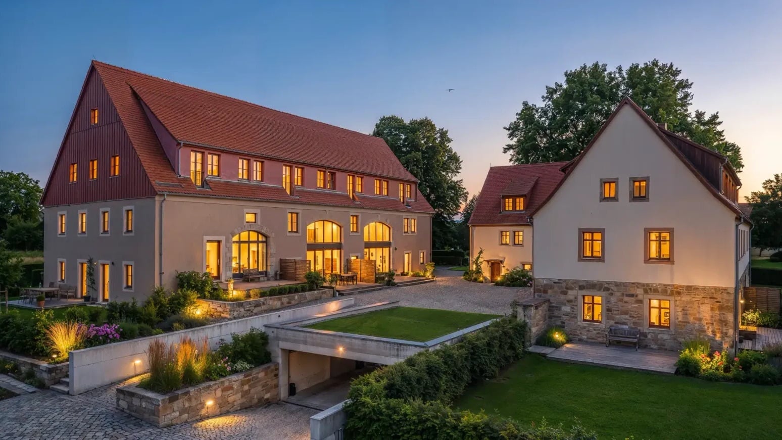 BaumGut Bannewitz — Dreiseitenhof mit Scheune und Wohnhaus in der Abenddämmerung, beleuchtete Fenster